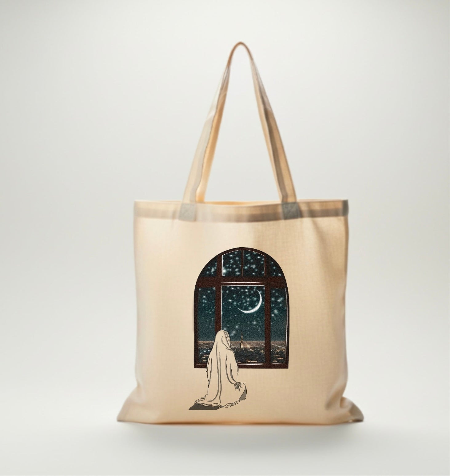 Canvas bag beige avec dessin d’une femme voilée priant devant une fenêtre ouverte sur un ciel étoilé et un croissant de lune.