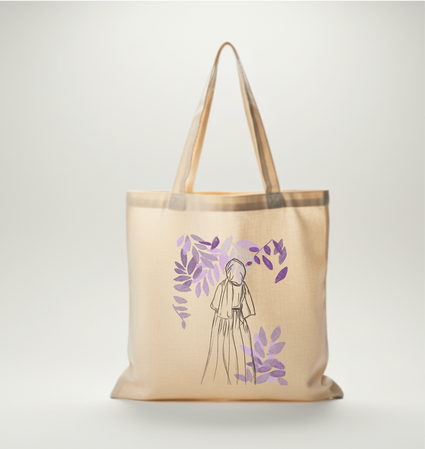 sac en toile Seni'Stuff avec dessin minimaliste de femme voilée et feuilles violettes, posé sur une chaise près d’un rideau