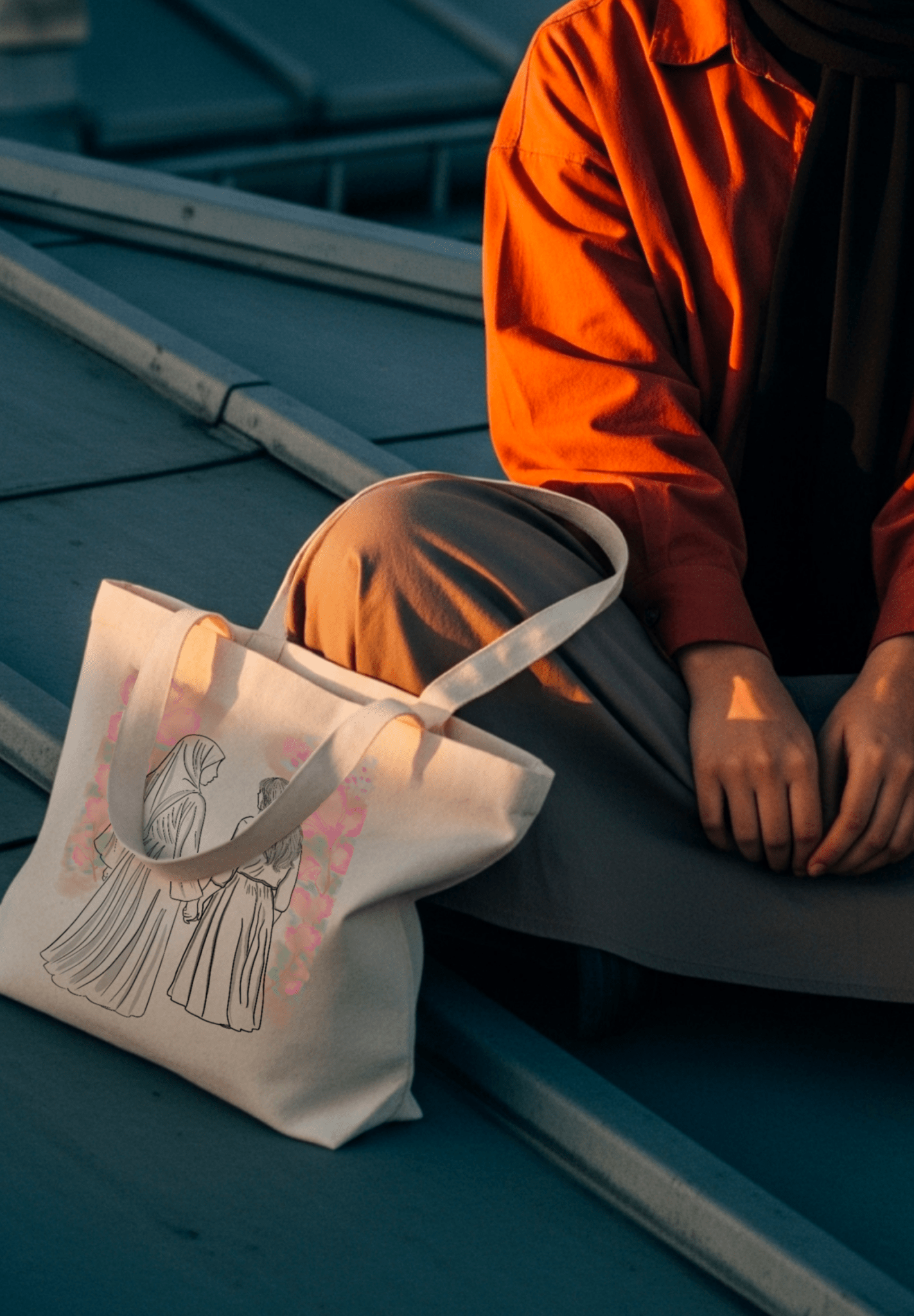 Sac en toile avec illustration de femme voilée entourée de fleurs roses et oranges, sur les toits de paris 
